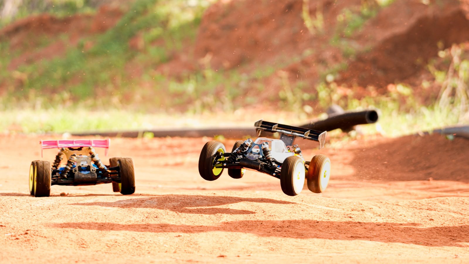 Radio-controlled buggies racing on a dirt track